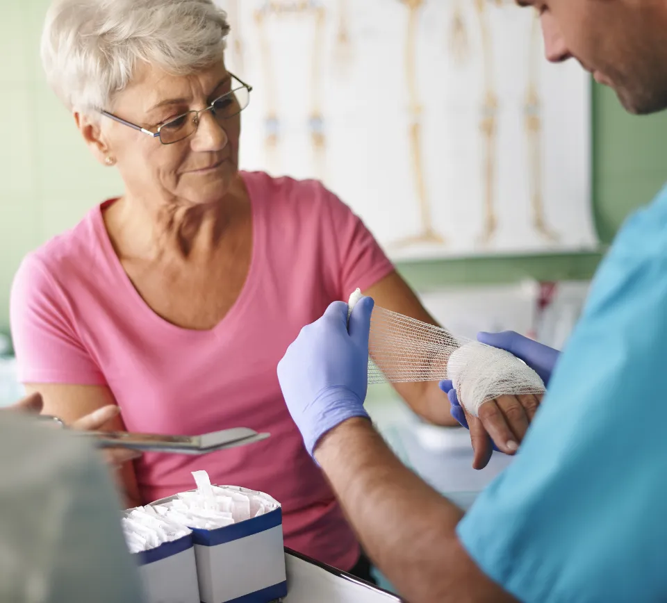 A provider applying a wound dressing to a resident’s hand